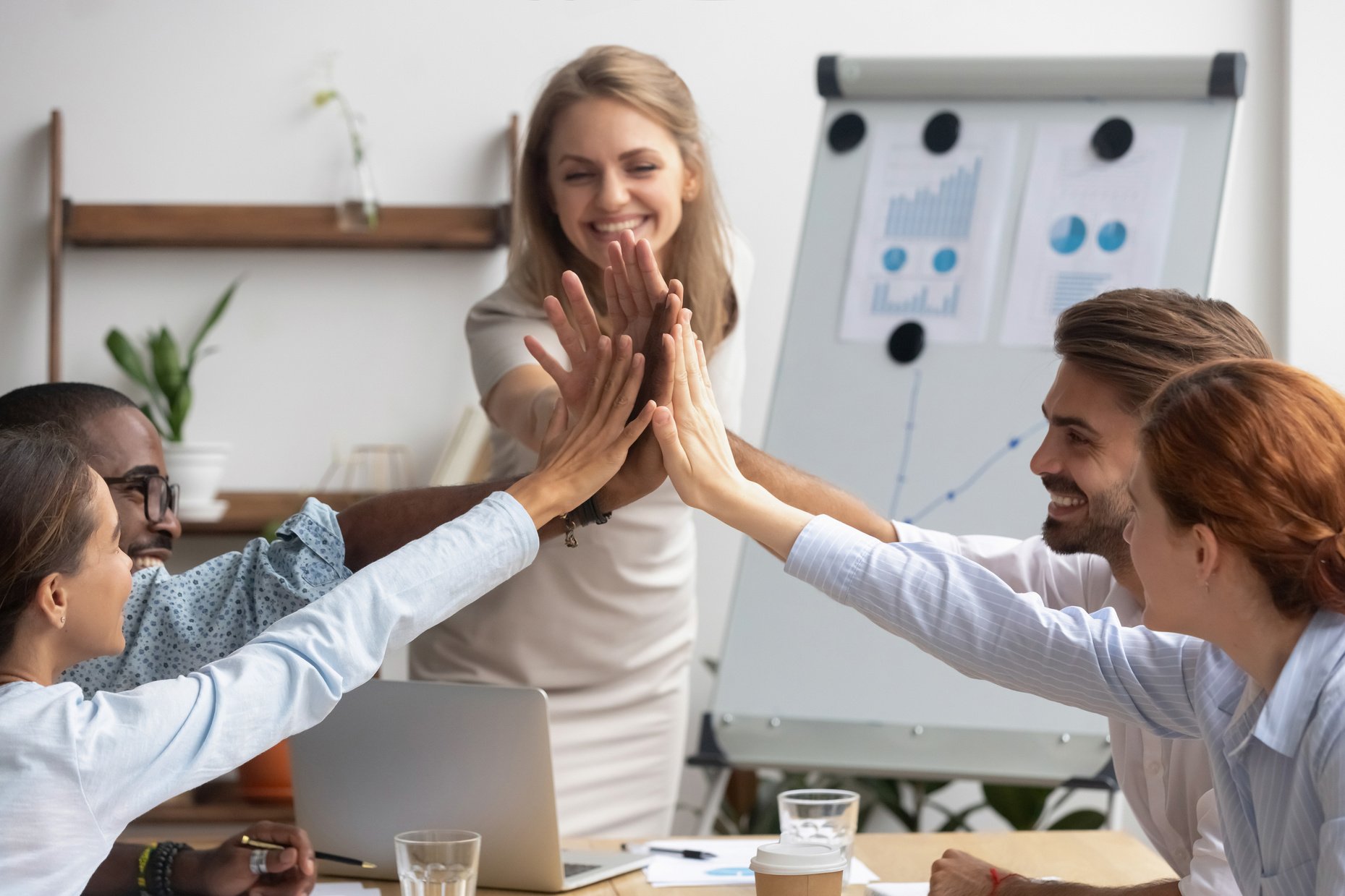 Smiling team leader with employees team giving high five